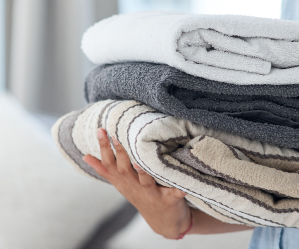 Hands Holding Stack Of Towels 1920X650